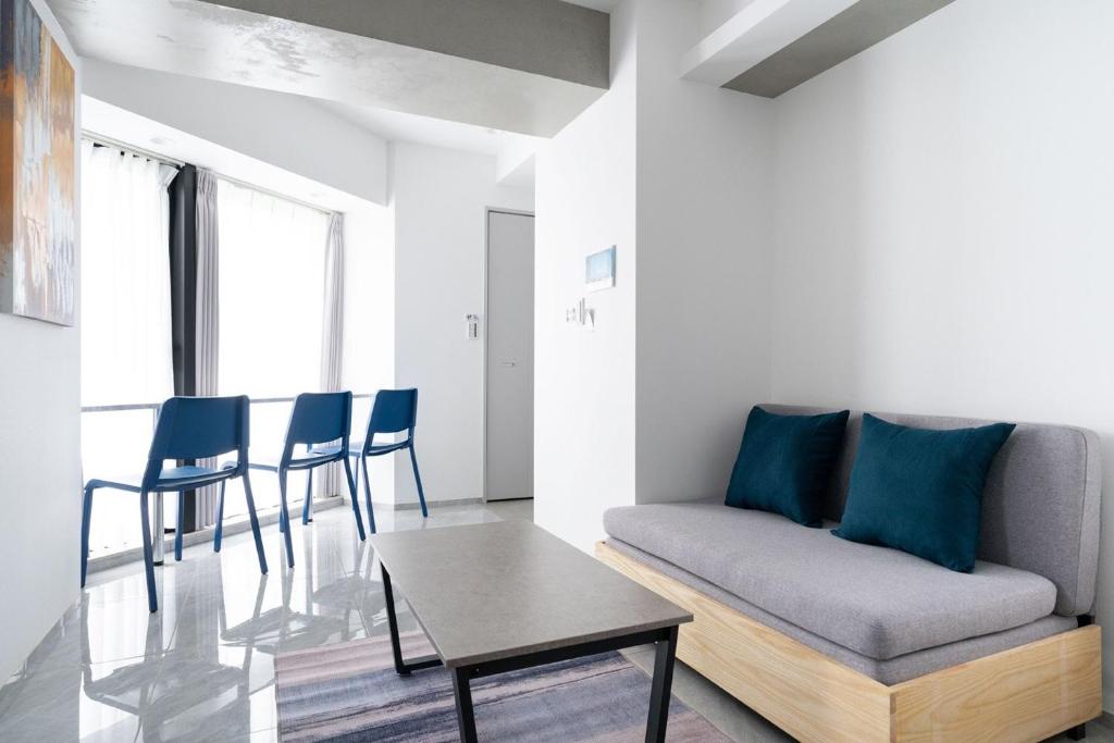 een woonkamer met een bank en een tafel bij Shinsen Hombe BLD in Tokyo
