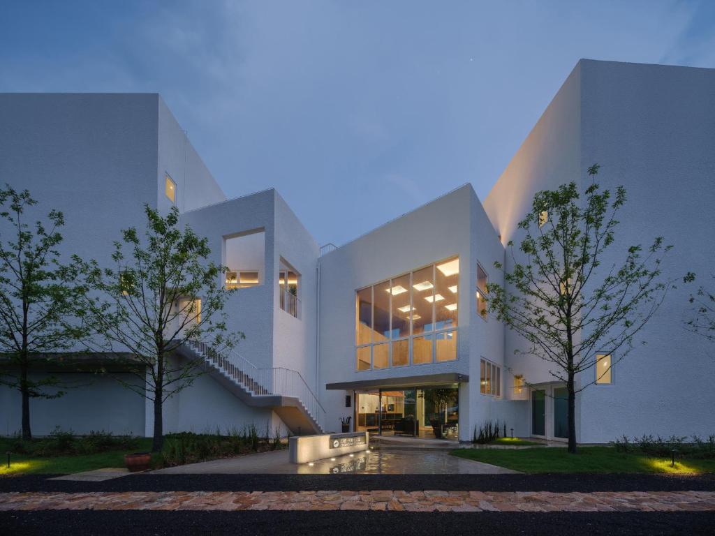 a white building with trees in front of it at 西坡劳岭良室民宿 in Wukang