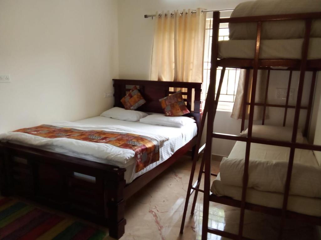 Postel nebo postele na pokoji v ubytování Kamadhenu Residency Homestay & Service Apartment Coorg Madikeri