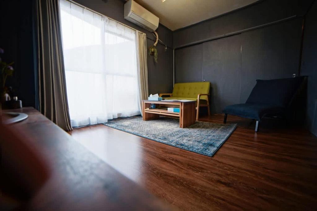 a living room with a couch and a table at "Route 99" Balinese style room, free Swith&Netflex in Hakone