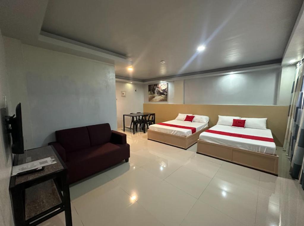un soggiorno con due letti e un divano di RedDoorz at FJ Hotel Tubungan Iloilo a Tubungan