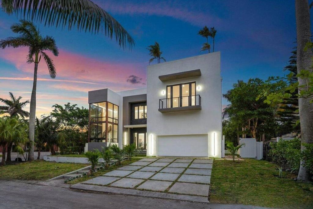 a white house with palm trees in front of it at Heated Pool & Rooftop Near Intracoastal in Boynton Beach