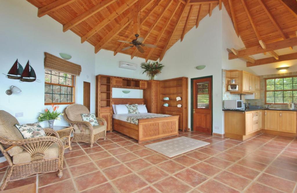 a living room with a bed and a kitchen at Tropical Hideaway in Port Elizabeth
