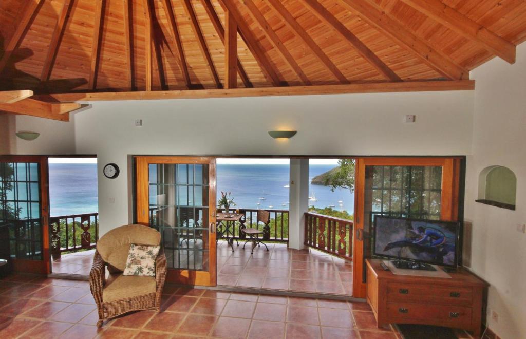 a living room with a tv and a balcony at Tropical Hideaway in Port Elizabeth