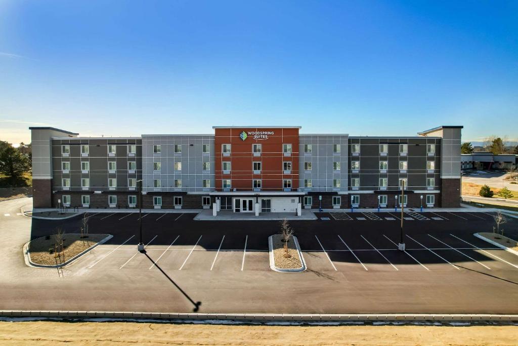 a large building with a parking lot in front of it at WoodSpring Suites Centennial - Denver Tech Center in Centennial