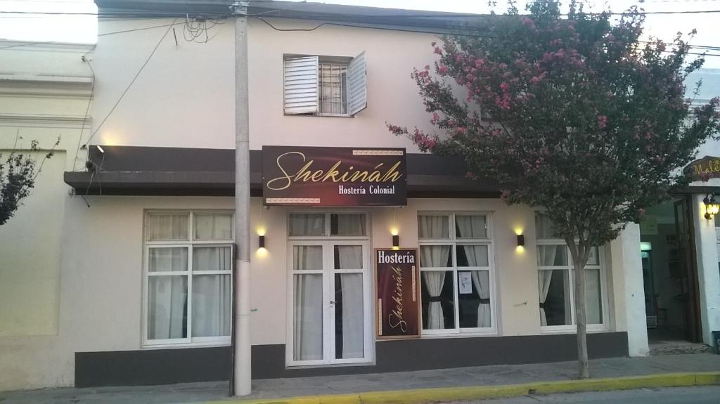 a pink and white building with a sign on it at Shekináh in Villa Cura Brochero