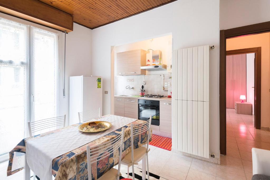 eine Küche mit einem Tisch und einem weißen Kühlschrank in der Unterkunft Rogoredo Apartments in Mailand