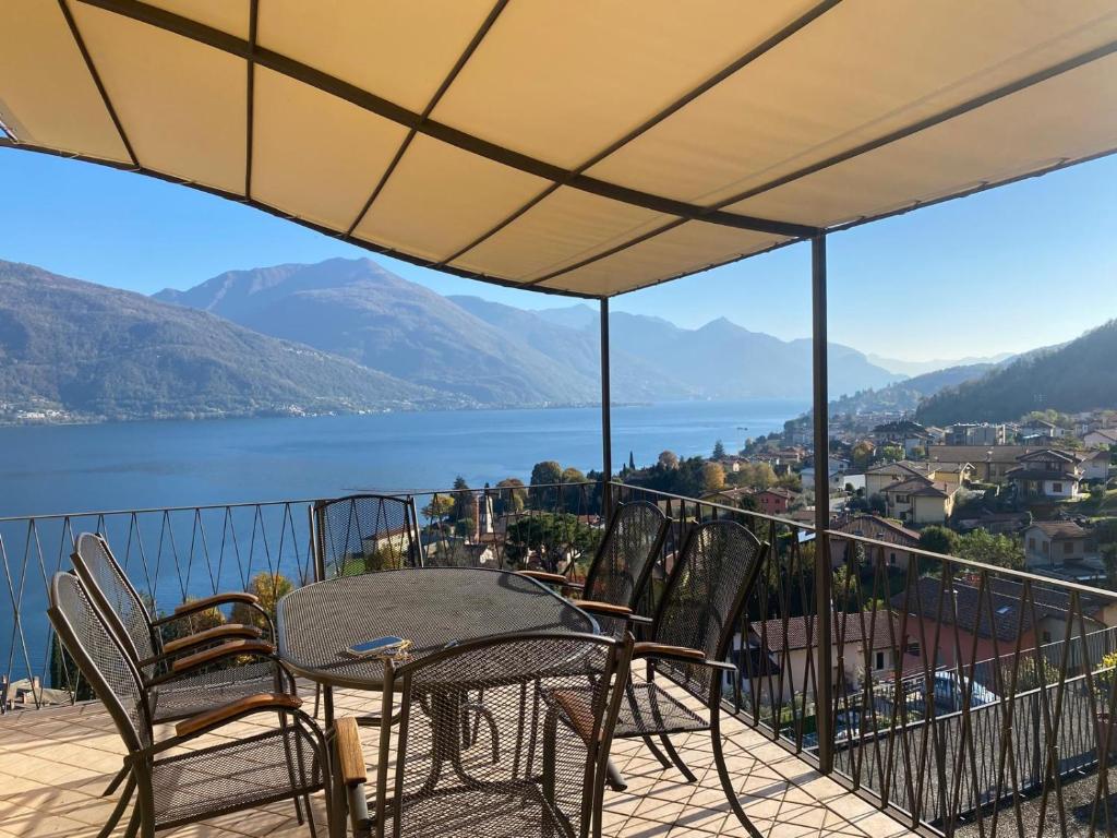 a table and chairs on a balcony with a view of the water at Luxury Residence La Pianca - Pool and Terrace Lake View in Musso