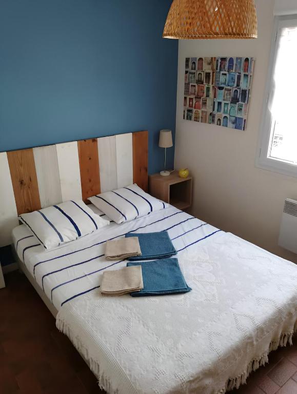 - un grand lit blanc avec 2 serviettes dans l'établissement Plage des Chalets, à Gruissan