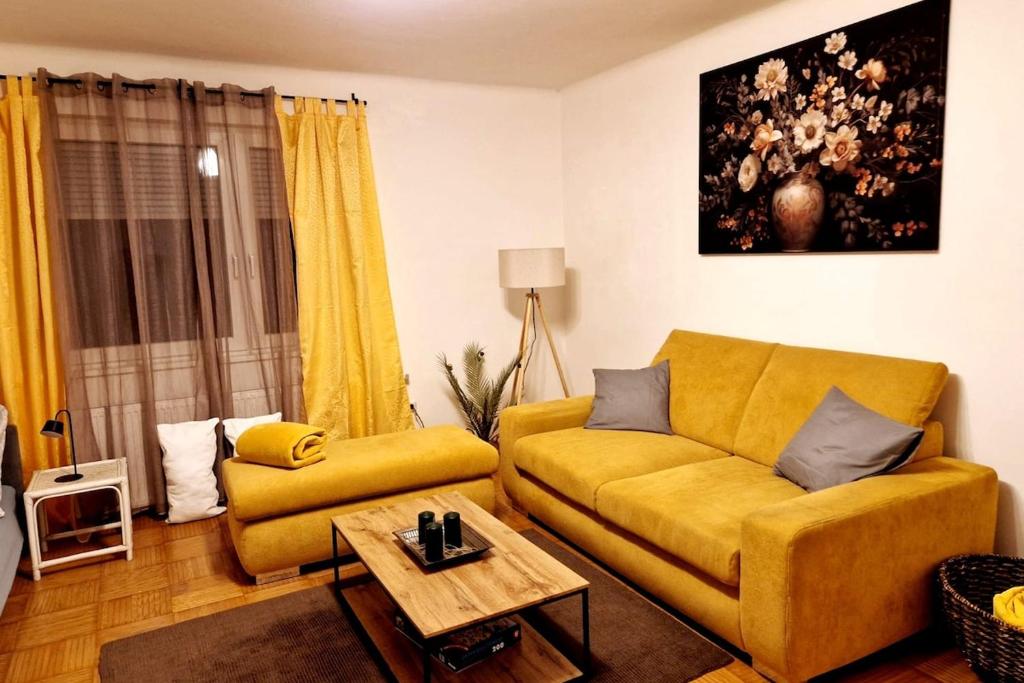 a living room with a yellow couch and a table at Ruhiges und großzügiges Appartement in Sankt Valentin