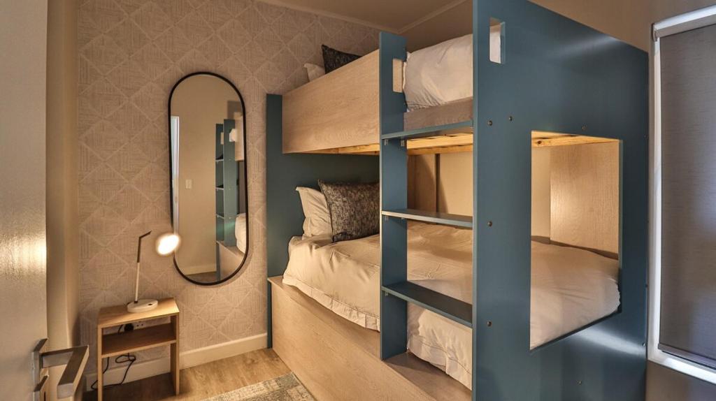 a bedroom with a bunk bed with a mirror at 105 Mossel Cove Unique & Trendy in Mossel Bay