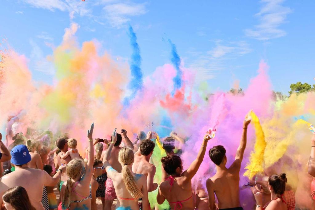a group of people standing in front of colored smoke at Camping Village Capalonga in Bibione