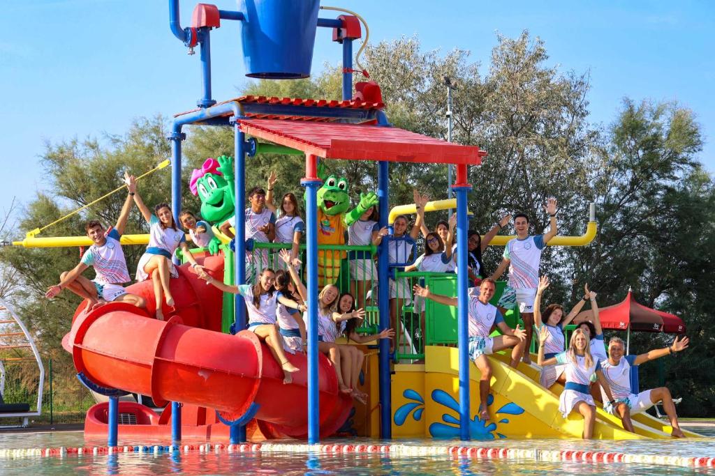 a group of children playing on a water slide at a water park at Camping Village Capalonga in Bibione