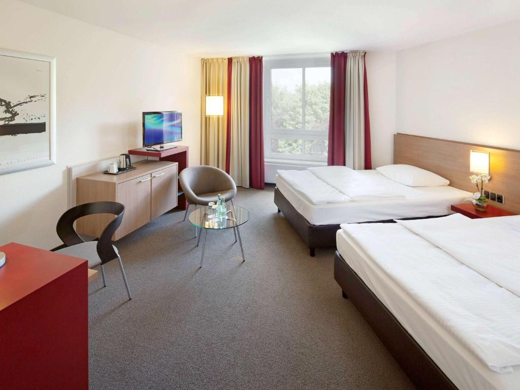 Postel nebo postele na pokoji v ubytování Mövenpick Hotel Münster am Aasee