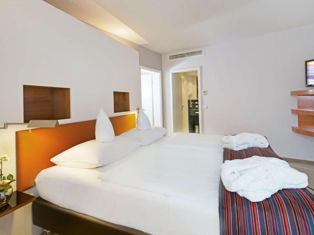 Postel nebo postele na pokoji v ubytování Mövenpick Hotel Münster am Aasee