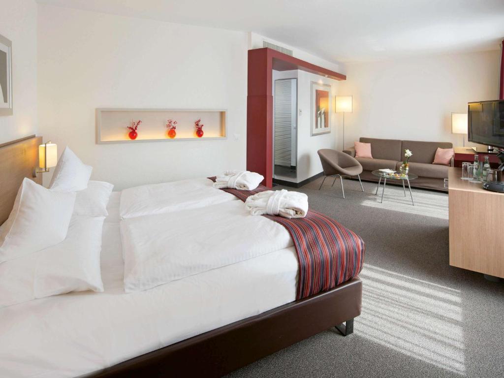 Postel nebo postele na pokoji v ubytování Mövenpick Hotel Münster am Aasee