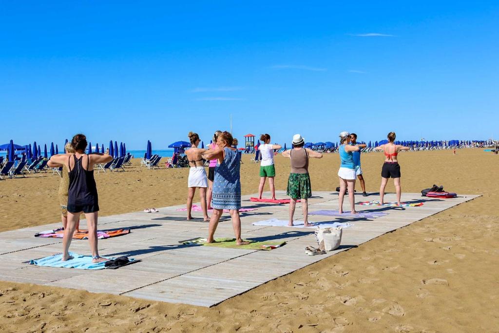 a group of people standing on the beach at Camping Lido in Bibione