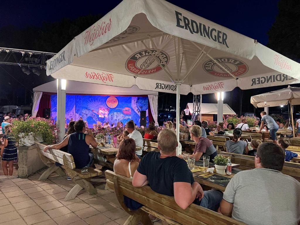 a group of people sitting at tables in a restaurant at Camping Lido in Bibione