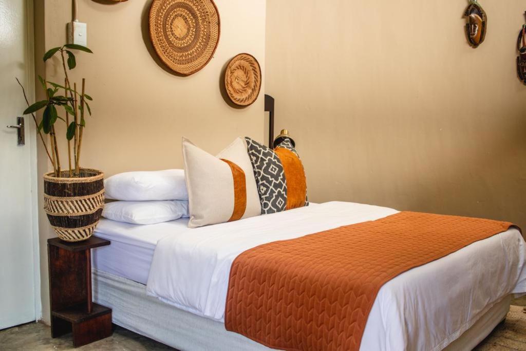 une chambre avec un lit avec des oreillers dessus dans l'établissement Wushwini Resort, à Durban