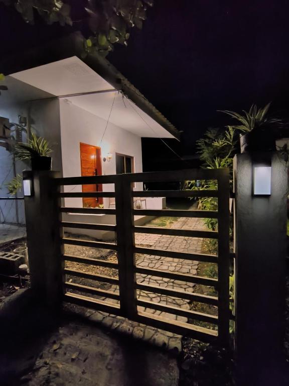 a small white house with a fence and a gate at Casa Marilag Guest House in Siquijor