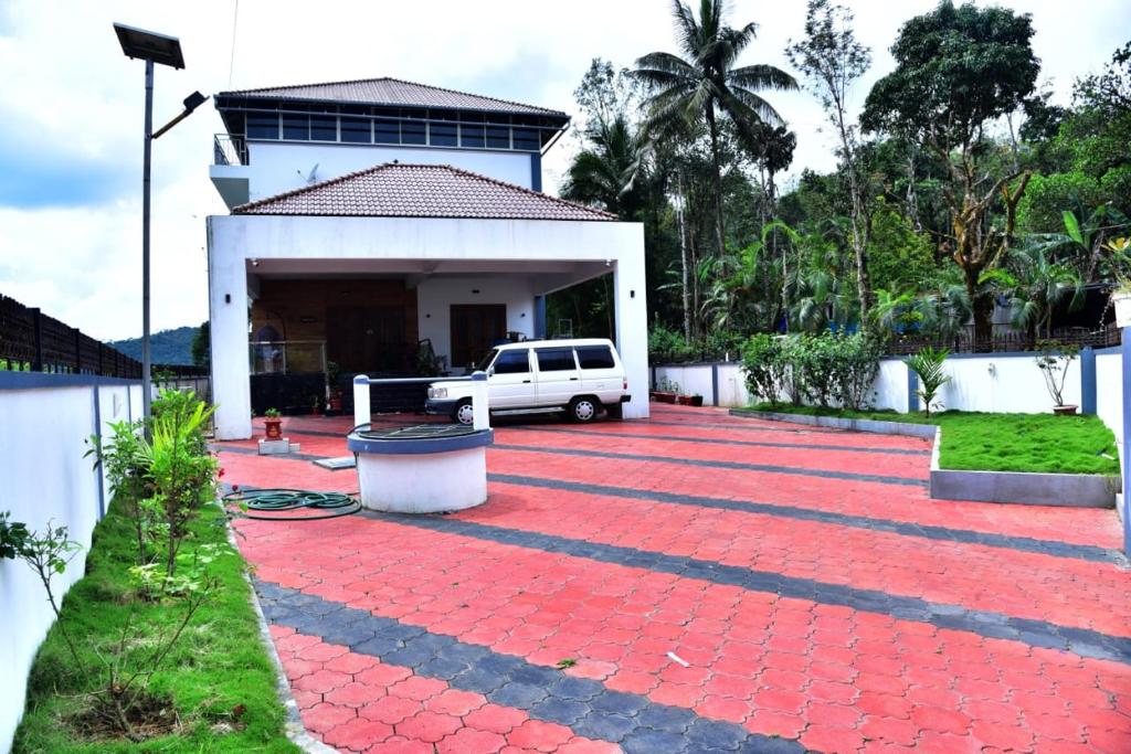 马迪凯里Coorg Balaji Palace Homestay Madikeri的一辆白色货车停在一所房子前面