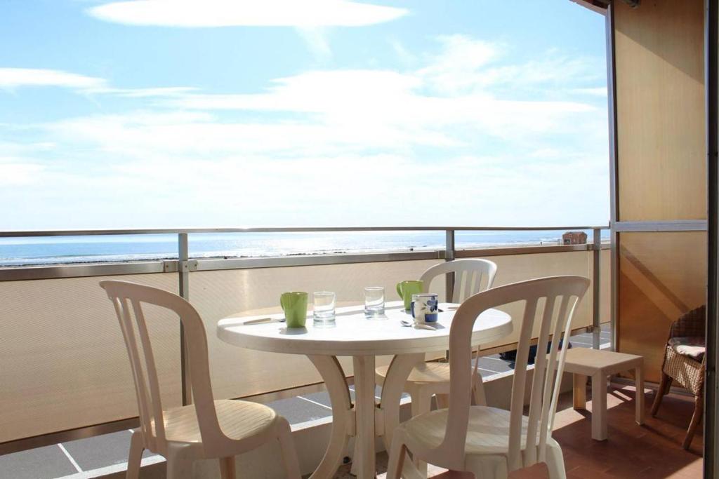une table et des chaises sur un balcon avec vue sur l'océan dans l'établissement Appartement 2 pièces PORT LA NOUVELLE PN210-047, à Port-la-Nouvelle