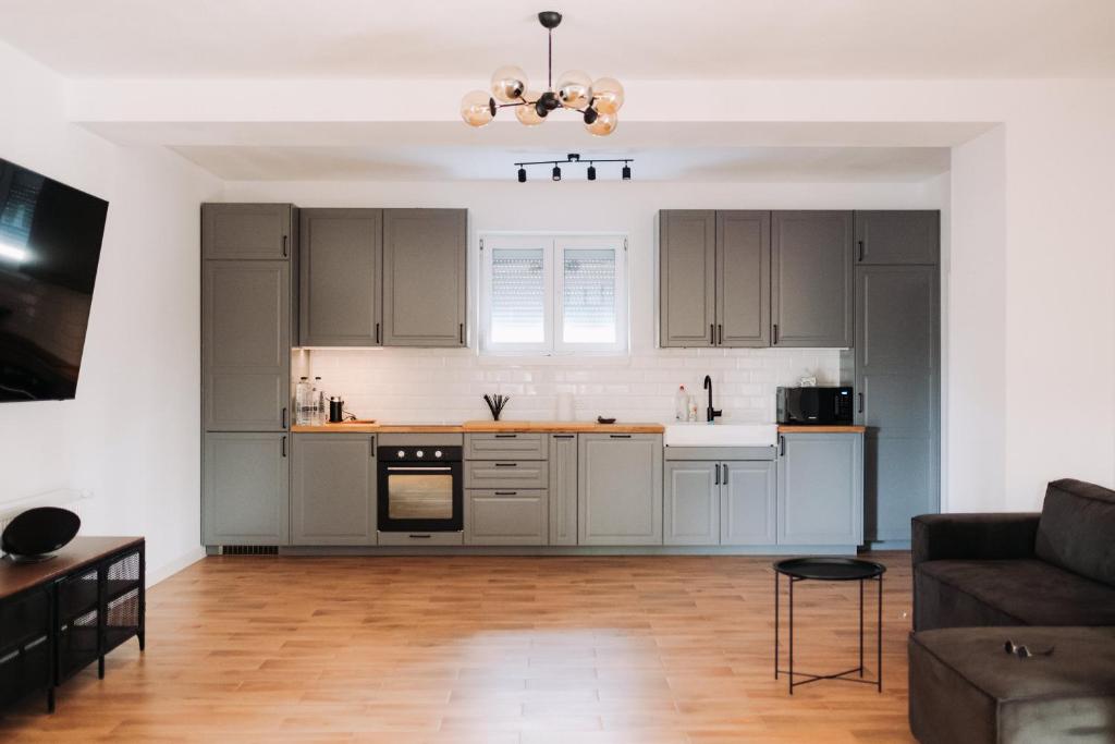 a kitchen with gray cabinets and a living room at Snagov Forest Villa in Ciolpani