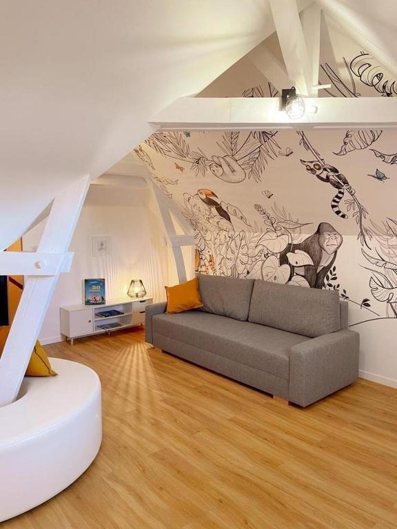 - un salon avec un canapé et une fresque murale dans l'établissement L'Arche de Noyers, à Noyers-sur-Cher