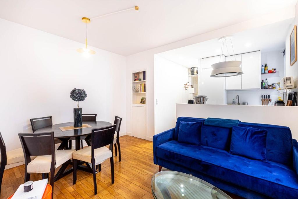 un salon avec un canapé bleu et une table dans l'établissement GuestReady - Parisian style home by la Bastille, à Paris