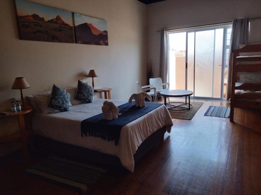 a bedroom with a bed with two teddy bears on it at The Mole Guesthouse in Swakopmund
