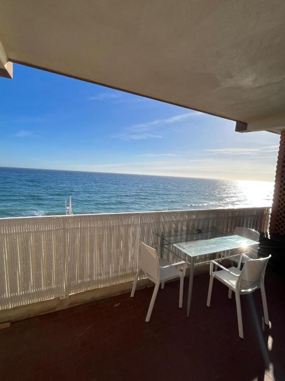 un balcon avec une table et des chaises et l'océan dans l'établissement Studio vue mer bord de plage, à San-Nicolao