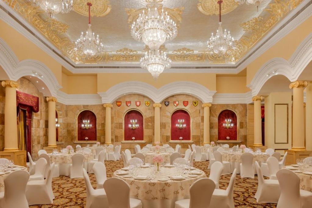 a ballroom with white tables and chairs and chandeliers at ITC Windsor, a Luxury Collection Hotel, Bengaluru in Bengaluru
