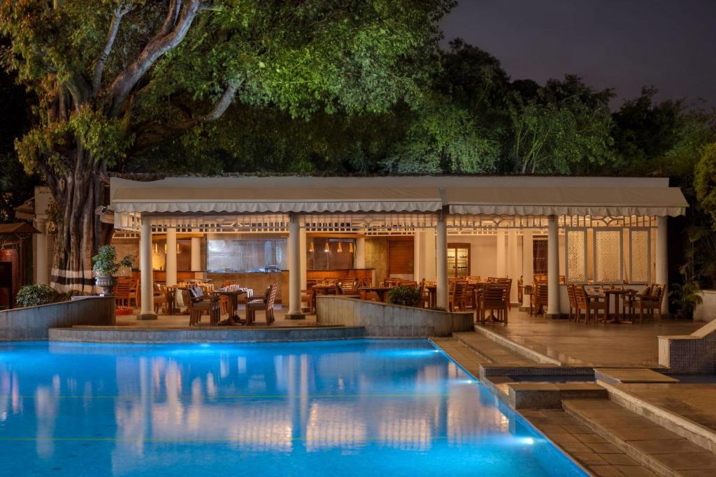 a swimming pool in front of a restaurant at night at ITC Windsor, a Luxury Collection Hotel, Bengaluru in Bengaluru