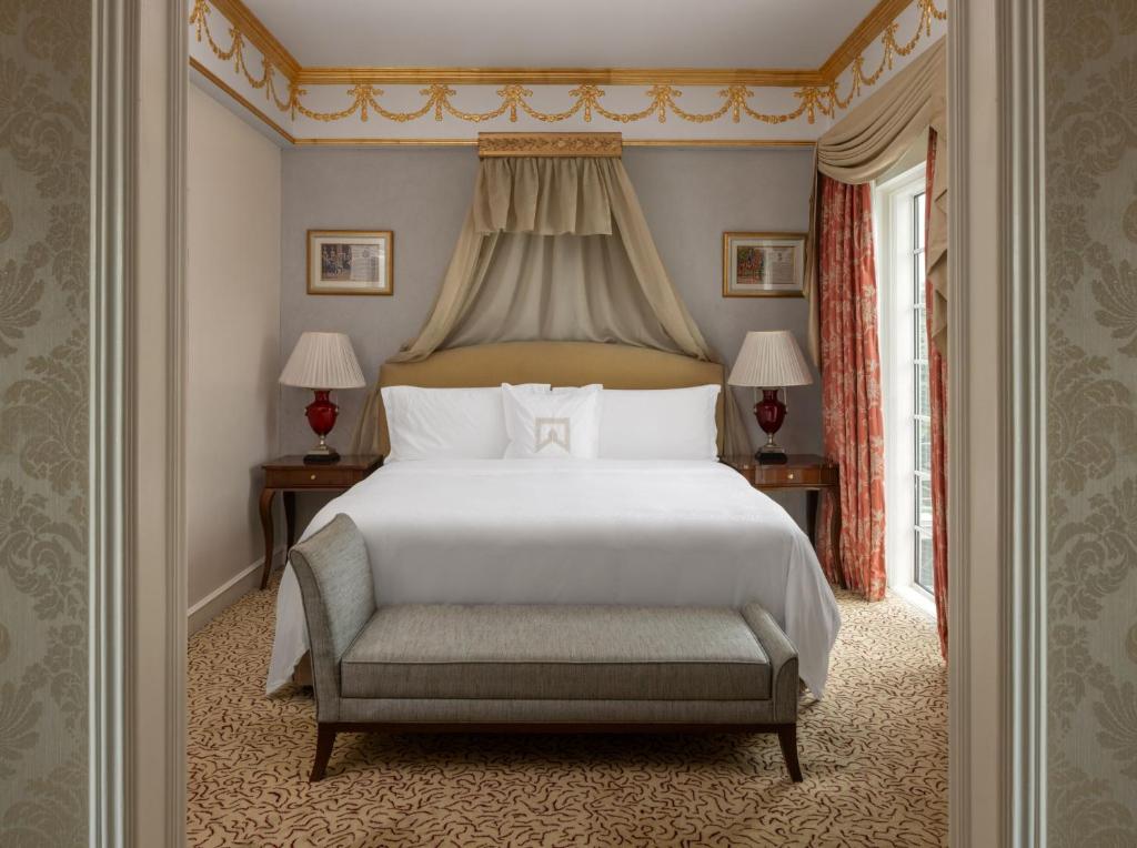 a bedroom with a large white bed and a chair at ITC Windsor, a Luxury Collection Hotel, Bengaluru in Bengaluru