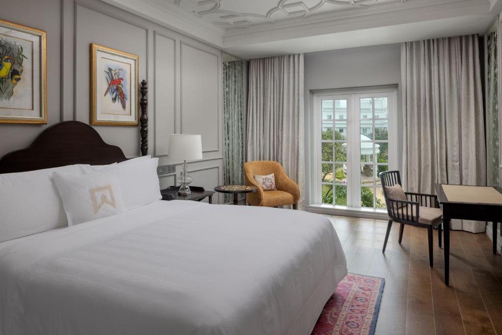 a bedroom with a large white bed and a desk at ITC Windsor, a Luxury Collection Hotel, Bengaluru in Bengaluru