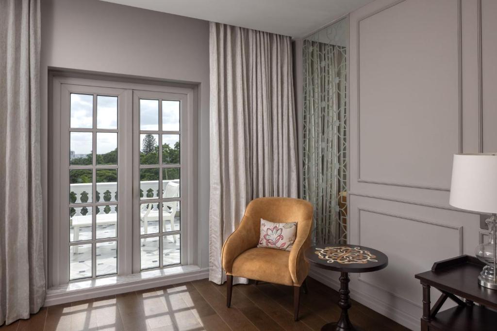 a living room with a chair and a window at ITC Windsor, a Luxury Collection Hotel, Bengaluru in Bengaluru