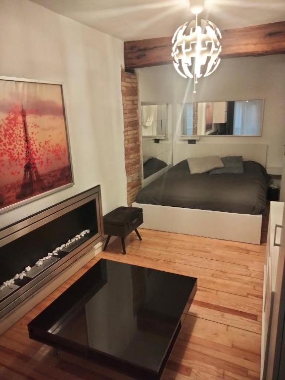 a bedroom with a bed and a fireplace and a chandelier at San Nicolas by clabao in Pamplona