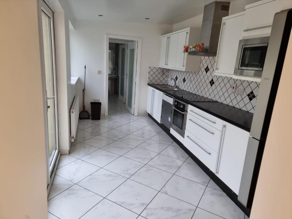 a kitchen with white cabinets and a tile floor at Portobello City Centre Dublin 8 Sleep 5 in Dublin