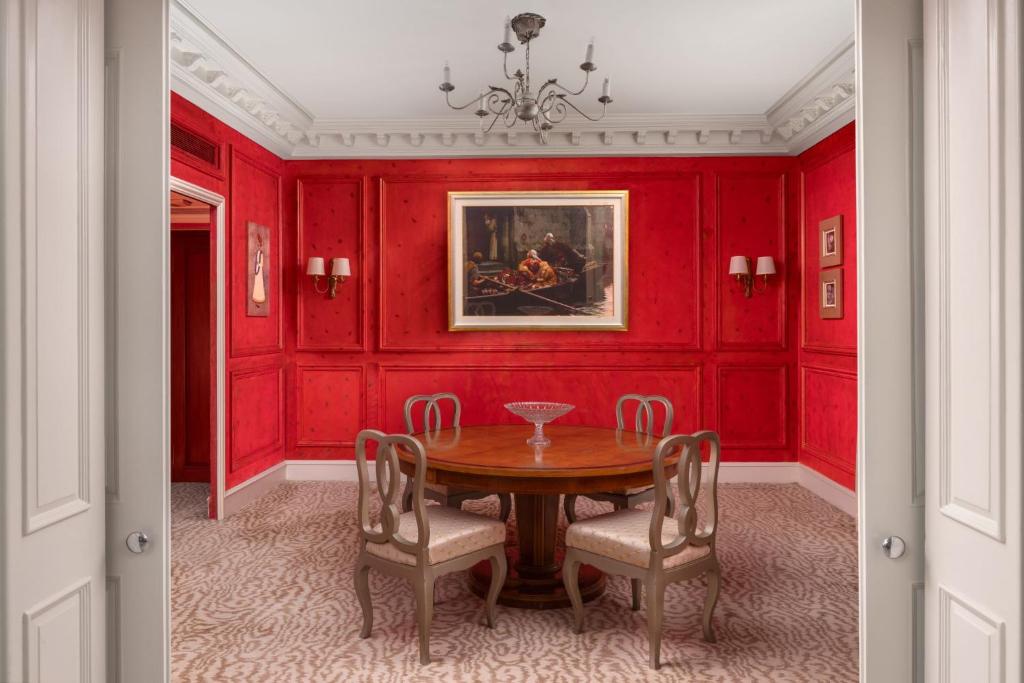 a dining room with red walls and a table and chairs at ITC Windsor, a Luxury Collection Hotel, Bengaluru in Bengaluru