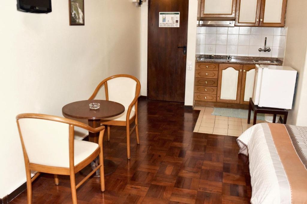 una piccola camera con tavolo e sedie e una cucina di Charming studio in Funchal, 30m², city view a Funchal