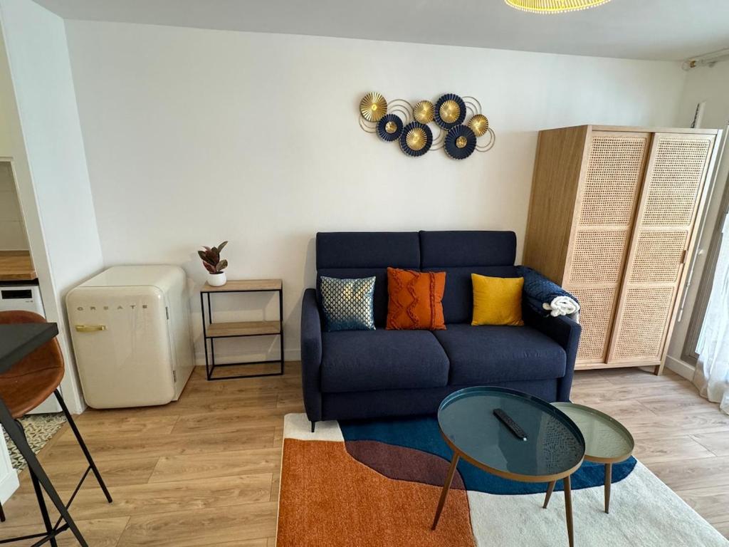 un salon avec un canapé bleu et une table dans l'établissement Furnished studio Paris 17, à Paris