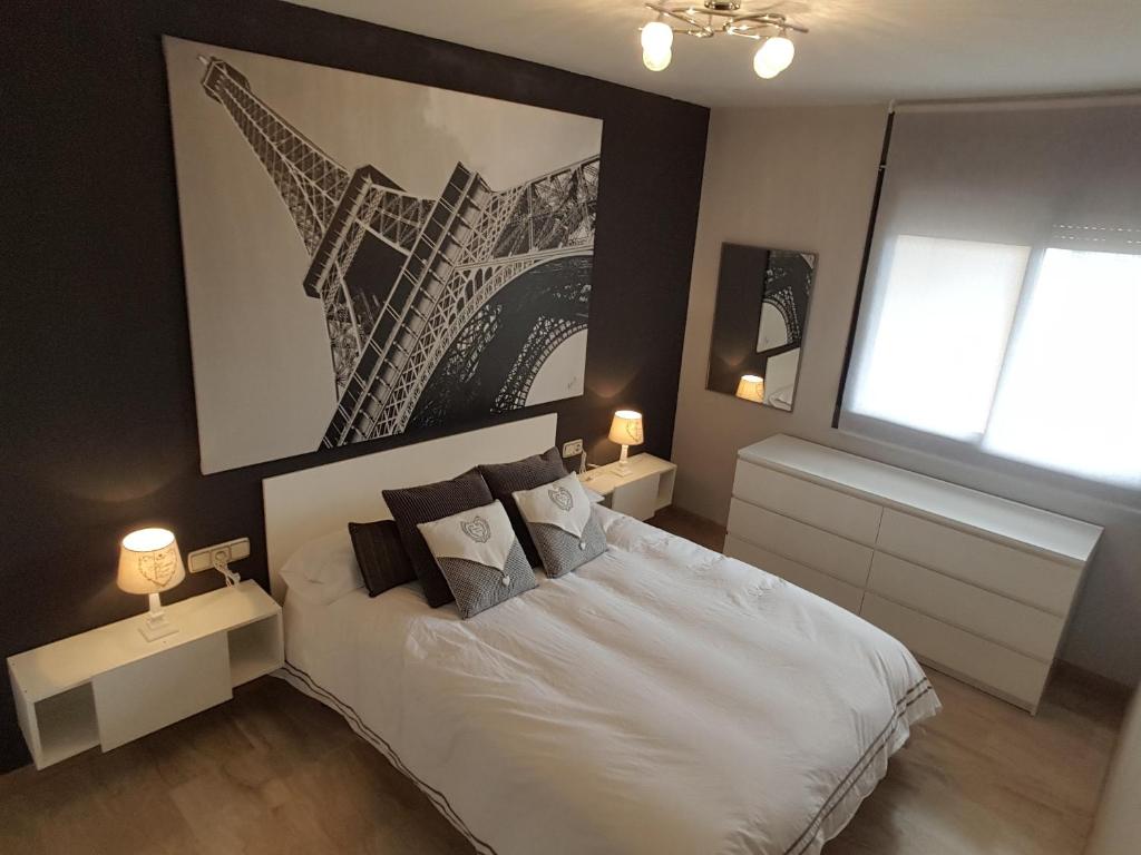sypialnia z białym łóżkiem z dwoma stołami i oknem w obiekcie Residencial Torres Roma w mieście Tarragona