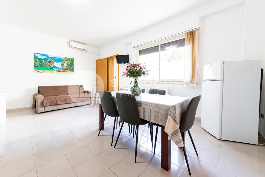 una cucina e una sala da pranzo con tavolo e sedie di Silver Bay Apartments a Porto Cesareo