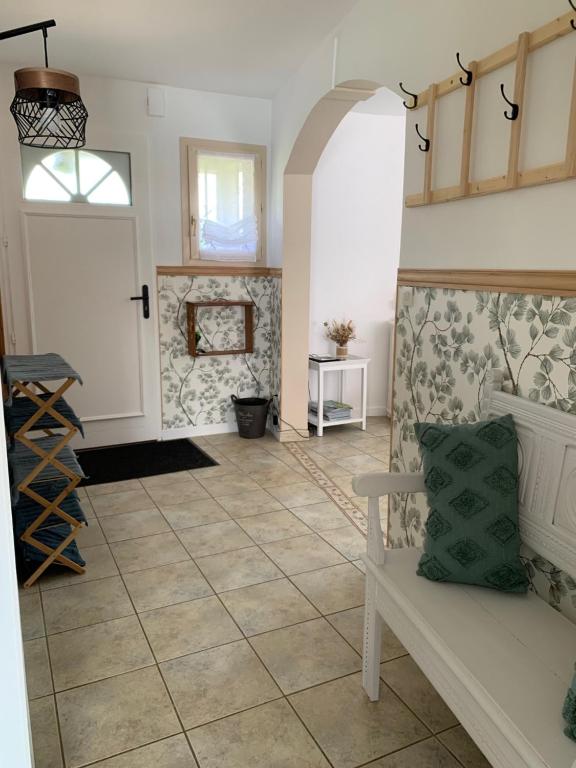a living room with a bench and a tile floor at Gite de Groupe Aux Instants Partagés in Fontenay-sur-Vègre