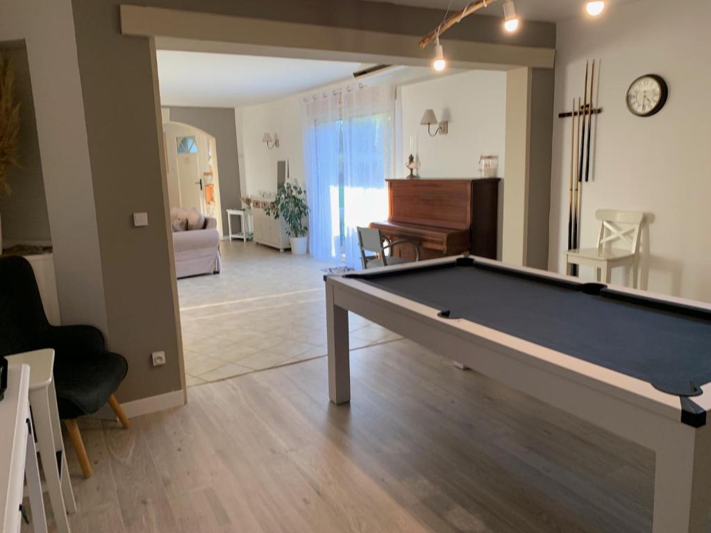 a living room with a pool table and a piano at Gite de Groupe Aux Instants Partagés in Fontenay-sur-Vègre