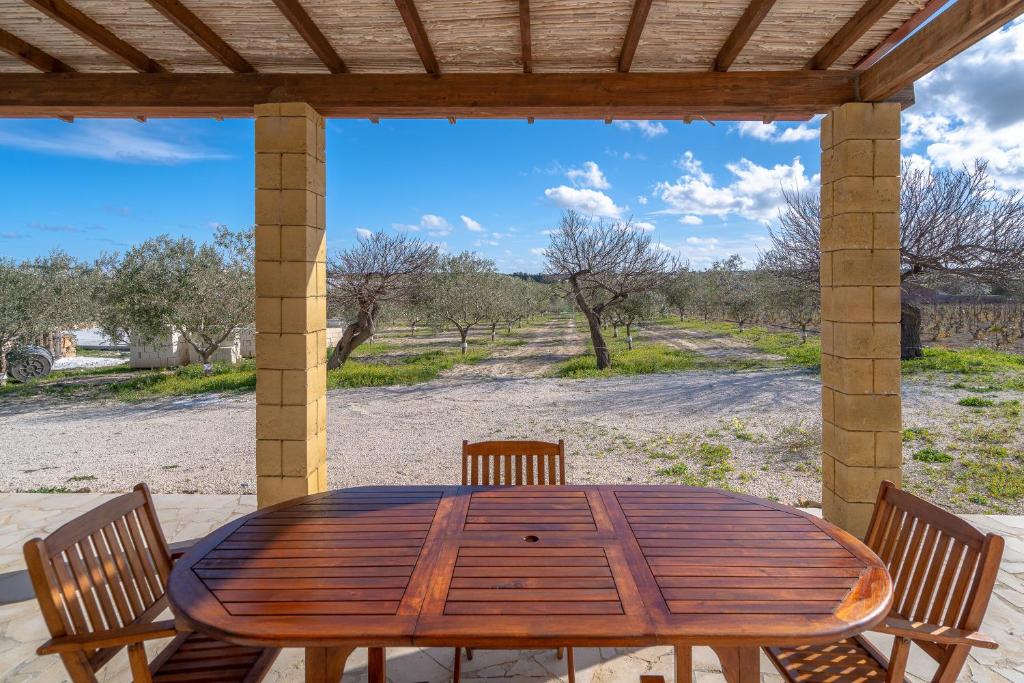 マルツァメミにあるCasa degli Uliviのパティオにある木製のテーブルと椅子