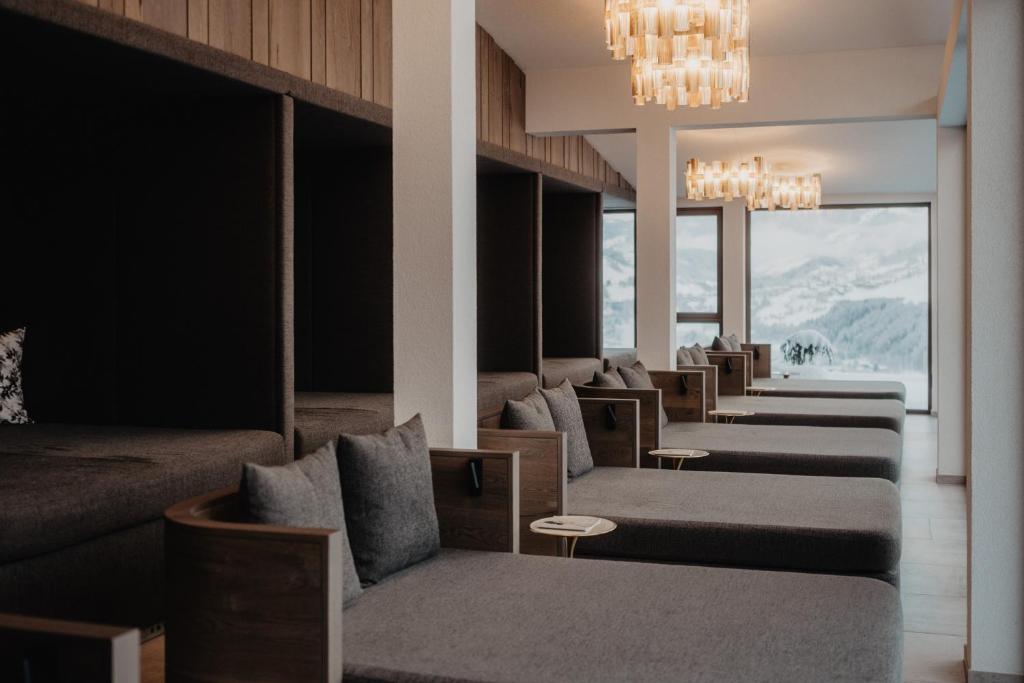 a hotel lobby with couches and tables and windows at Hotel Berghof - St Johann in Salzburg in Sankt Johann im Pongau