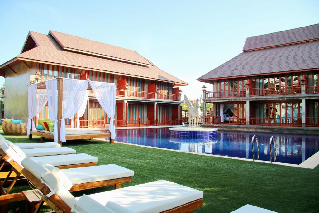 um resort com uma piscina em frente a um edifício em The Chaya Resort and Spa em Chiang Mai