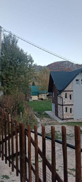 a wooden fence in front of a house at Apartmani Villa Deleon Bjelasnica in Trnovo