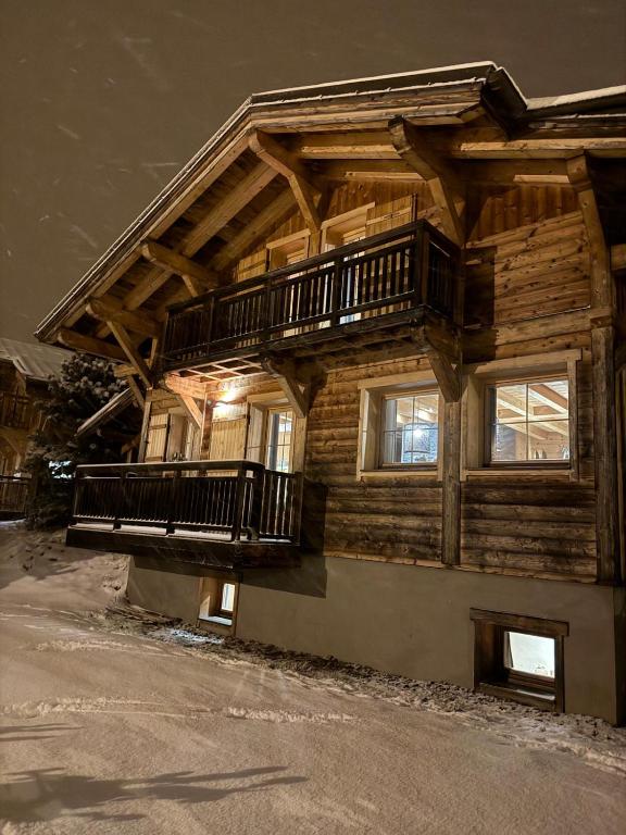 Cette maison en bois dispose d'un balcon sur le côté. dans l'établissement Chalet Nuances certifié 5 étoiles, aux Contamines-Montjoie